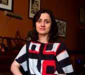 retrato de Camila Fresca com roupa branca, preta e laranja