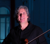 Marcelo Jaffé sorrindo com viola disposta sobre os braços